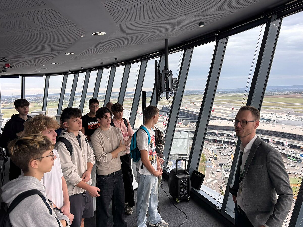 Flughafen Wien: Gruppe Jugendlicher und Mann mit Brille im Tower